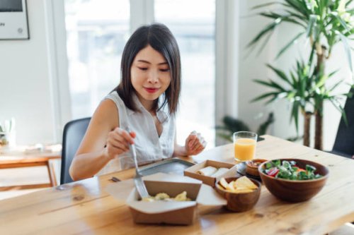 young woman eating healthy takeaway meal at home - junk food stock pictures, royalty-free photos & images