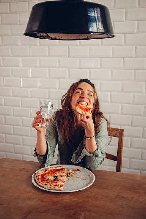 young woman eating pizza in restaurant - food stock pictures, royalty-free photos & images