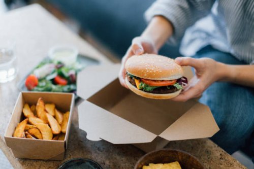 young woman eating takeaway food - junk food stock pictures, royalty-free photos & images