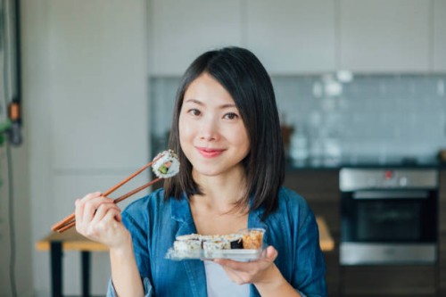 young woman eating takeaway sushi rolls - junk food stock pictures, royalty-free photos & images