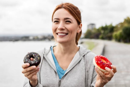 young woman enjoying a sweet treat - junk food stock pictures, royalty-free photos & images