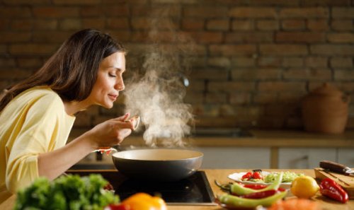 young woman enjoying while cooking meal in the kitchen. - food stock pictures, royalty-free photos & images