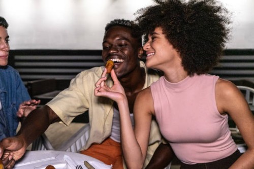 young woman feeding her boyfriend on restaurant - food stock pictures, royalty-free photos & images