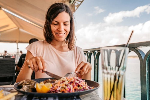young woman having lunch by the sea - food stock pictures, royalty-free photos & images