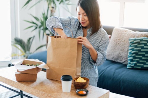 young woman having takeaway meal at home - food stock pictures, royalty-free photos & images