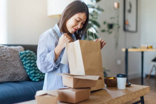 young woman having takeaway meal at home - junk food stock pictures, royalty-free photos & images