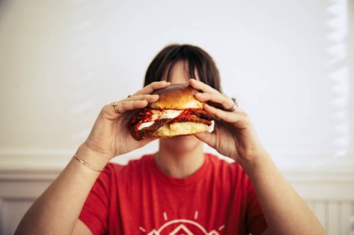young woman holding a large sandwich - junk food stock pictures, royalty-free photos & images