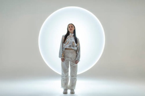 young woman in front of a circular light shape - fashion stock pictures, royalty-free photos & images