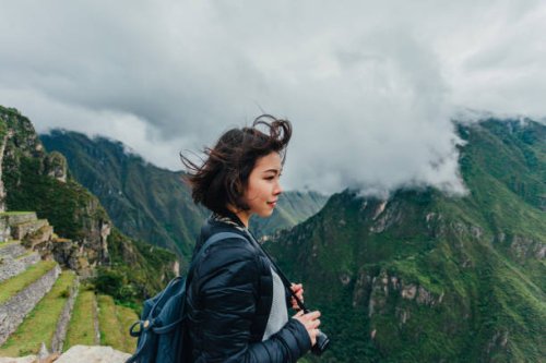 young woman looking at view from machu picchu in peru - travel stockfoto's en -beelden