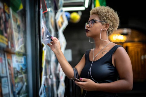young woman looking for the news at newsstand - fashion stock pictures, royalty-free photos & images