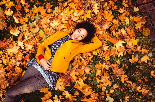 young woman lying down on yellow leaves - fashion stock pictures, royalty-free photos & images