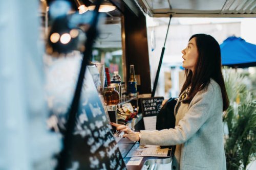 young woman ordering food and drinks from food truck - junk food stock pictures, royalty-free photos & images