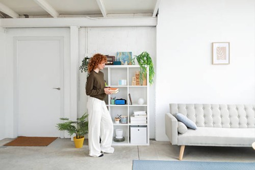 young woman organizing books in modern living room - home decoration stock pictures, royalty-free photos & images