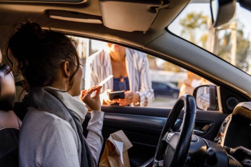 young woman paying with a credit card at the curbside pickup - junk food stock pictures, royalty-free photos & images