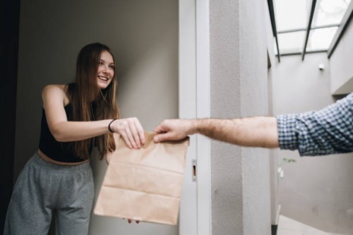 young woman receiving food delivery at home - food stock pictures, royalty-free photos & images