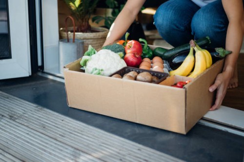 young woman receiving fresh food home delivery - junk food stock pictures, royalty-free photos & images
