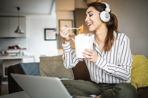 young woman relaxing at home and eating pasta - junk food stock pictures, royalty-free photos & images