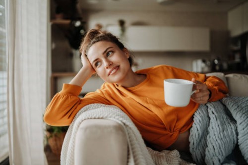 young woman resting on sofa with cup of tea. - home decoration stock pictures, royalty-free photos & images