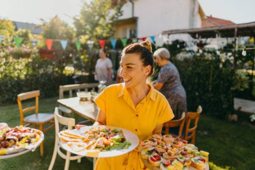 young woman serving food at outdoors dinner party - food stock pictures, royalty-free photos & images