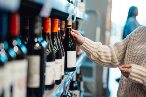 young woman shopping wine in supermarket - junk food stock pictures, royalty-free photos & images