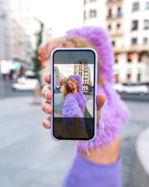 young woman showing selfie on smart phone - fashion photos et images de collection