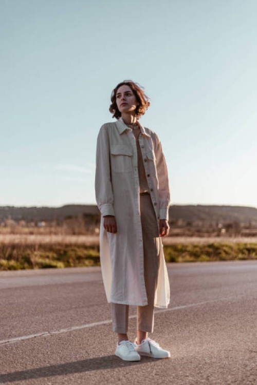 young woman standing on road at sunrise - fashion stock pictures, royalty-free photos & images