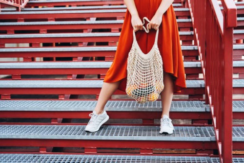 young woman standing with shopping net bag. - fashion stock pictures, royalty-free photos & images