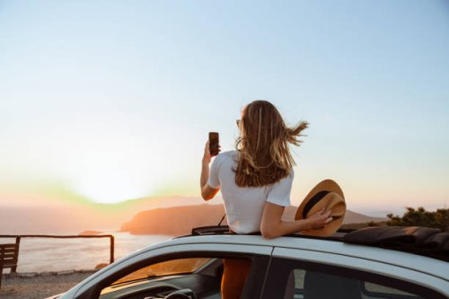 young woman taking a photo of the sunset - travel stock pictures, royalty-free photos & images