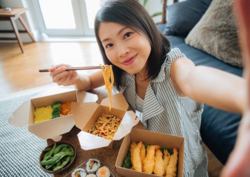 young woman taking selfie while eating takeaway food - junk food stock pictures, royalty-free photos & images