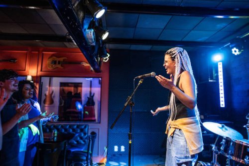 young woman talking during stand-up comedy show - concert stock pictures, royalty-free photos & images