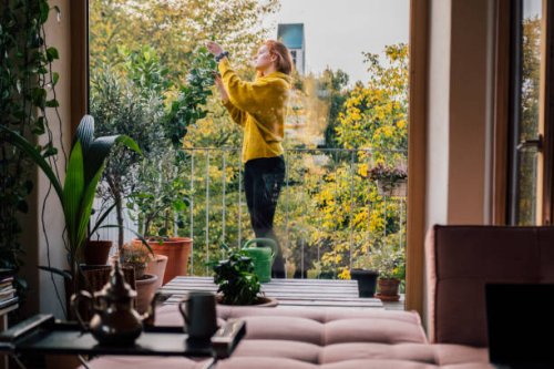 young woman tending to her plants on balcony - garden decoration stock pictures, royalty-free photos & images