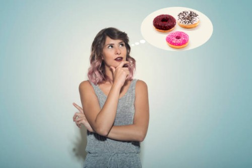 young woman thinking about an assortment of donuts - junk food stock pictures, royalty-free photos & images