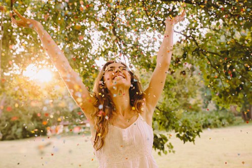 young woman throwing confetti in the park - garden decoration stock pictures, royalty-free photos & images
