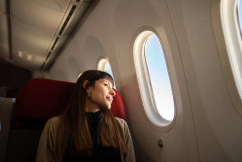 young woman traveling by plane looking out the window - travel stock pictures, royalty-free photos & images