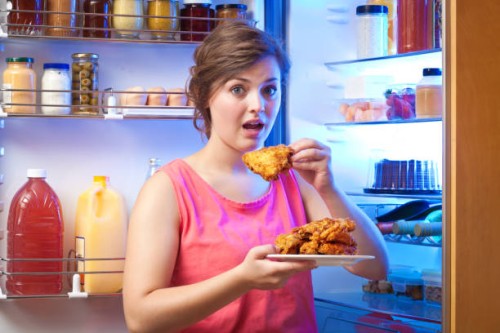 young woman unhealthy eating in front of refrigerator - junk food stock pictures, royalty-free photos & images