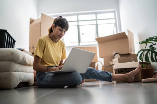 young woman using laptop at new house - home decoration stock pictures, royalty-free photos & images