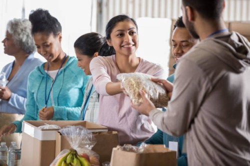 young woman volunteering in food bank - food stock pictures, royalty-free photos & images