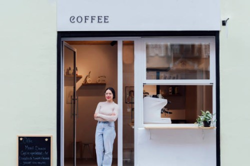young woman waitress at the door of the cafe - junk food stock pictures, royalty-free photos & images