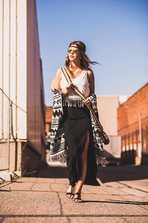 young woman wearing boho style walking on street - fashion stock pictures, royalty-free photos & images