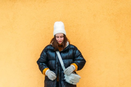 young woman while standing against yellow wall - fashion stock pictures, royalty-free photos & images