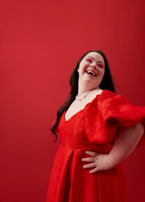 young woman with hand on hip against red background - fashion stock pictures, royalty-free photos & images