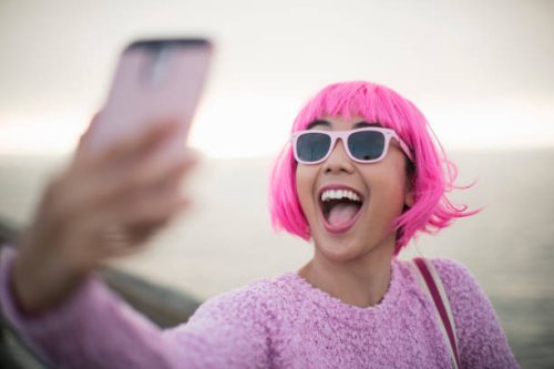 young woman with pink hair taking a selfie - hairstyle stock pictures, royalty-free photos & images