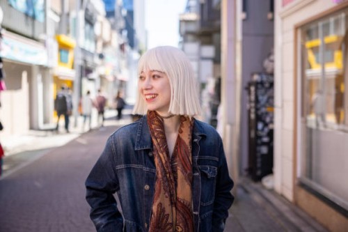 young woman with platinum blonde hair walking on shopping street with smile - fashion stock pictures, royalty-free photos & images