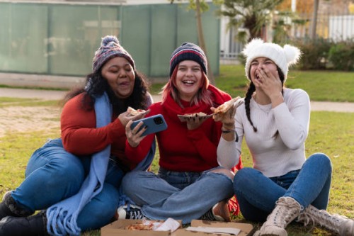 young women eating pizza and having fun in a public park - junk food stock pictures, royalty-free photos & images