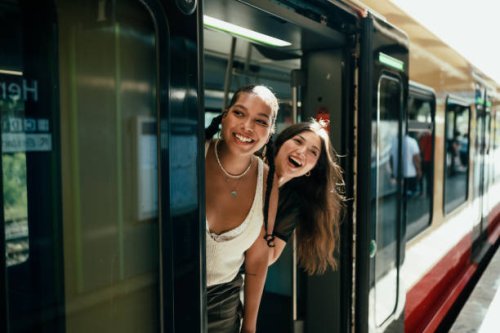 young women looking out of the train door - travel stock pictures, royalty-free photos & images