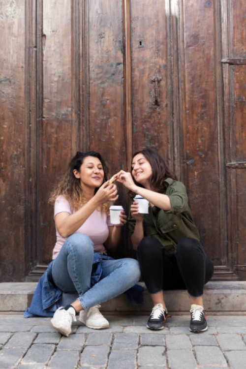 young women sharing cookies with coffee - junk food stock pictures, royalty-free photos & images