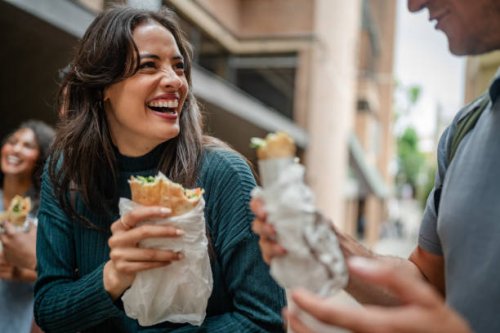 youth enjoy tasty street food while laughing and socializing in the vibrant streets of sydney, australia during the weekend - junk food stock pictures, royalty-free photos & images