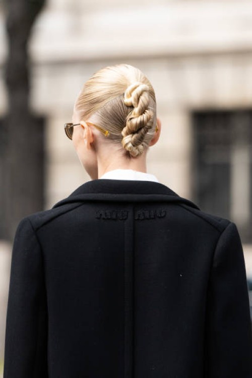 Yulia Lobova - Harfouch wears a Miu Miu coat and a twist in her hair outside the Miu Miu show during Womenswear Spring/Summer 2025 as part of Paris...