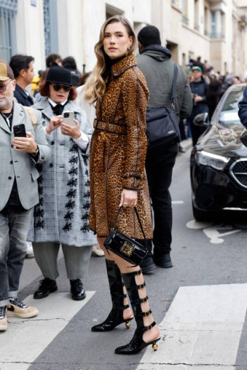 Zita d'Hauteville wears leopard print trench coat, black Dior bag, black Dior boots, outside Dior, during Womenswear Spring/Summer 2025 as part of...