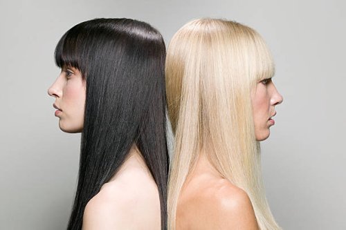 zwei frauen rücken an rücken - hairstyle stock-fotos und bilder
